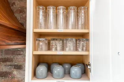 a cabinet filled with glass jars and vases at Stylish Euro Vibes Home, Small Gym, AC, Yard, Office in Edmonton