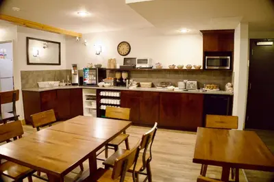 a kitchen with wooden tables and chairs and a counter at Glacier Mountain Lodge in Blue River