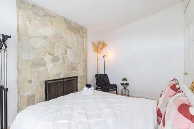 a bedroom with a stone wall and a bed at Beautiful Vancouver Special Home in Vancouver
