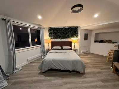 a bedroom with a bed and a large window at Cabin in the woods @ Cultus Lake in Chilliwack
