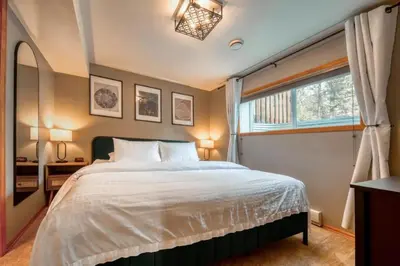 a bedroom with a large bed and a window at Radium 5BR Home Ping Pong, Foosball, & Gazebo in Radium Hot Springs