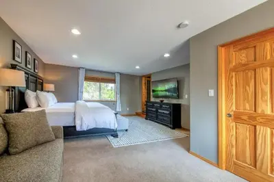 a bedroom with a large bed and a tv at Radium 5BR Home Ping Pong, Foosball, & Gazebo in Radium Hot Springs