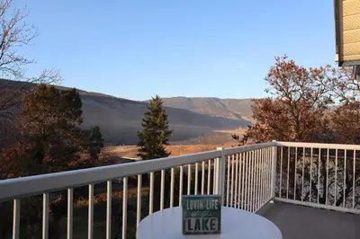 a table on a balcony with a view of the mountains at Blue Shore Resort in Savona