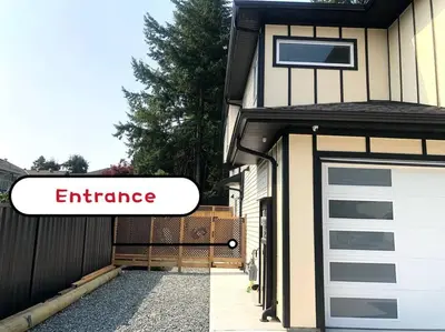 a garage door with an entrance sign on a house at Gorgeous 2 Bedrooms Suite Private entrance with patio-Free Parking in Maple Ridge District Municipality