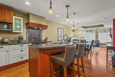 a kitchen with a counter and a bar with chairs at Luxury Resort 2Bedroom 2Bath Sleeps 6 945 square feet in Canmore