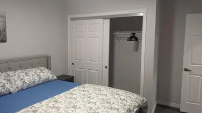 a bedroom with a bed and a door to a closet at Comfy one bedroom Airdrie in Airdrie