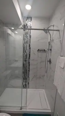 a shower with a glass door in a bathroom at Comfy one bedroom Airdrie in Airdrie
