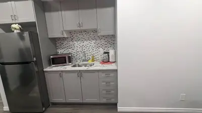 a kitchen with a sink and a refrigerator at Comfy one bedroom Airdrie in Airdrie
