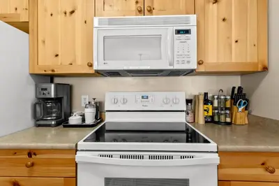 a white stove top oven with a microwave above it at Crystal Forest #51 condo in Sun Peaks