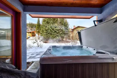 a jacuzzi tub on a porch with a window at Crystal Forest #51 condo in Sun Peaks