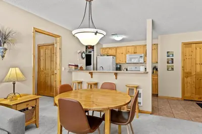 a dining room and kitchen with a table and chairs at Crystal Forest #51 condo in Sun Peaks