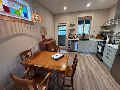 a kitchen with a wooden table and chairs in it at Cowichan Valley Guest Cottage in Ladysmith