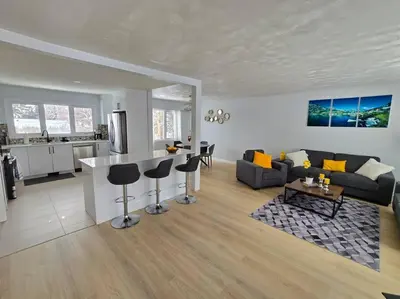 a living room and kitchen with a couch and a table at 3 Bedroom Home away from Home in Calgary