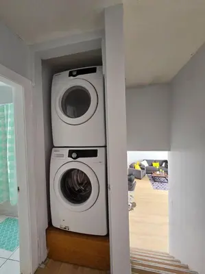 a washer and dryer in a room with a hallway at 3 Bedroom Home away from Home in Calgary