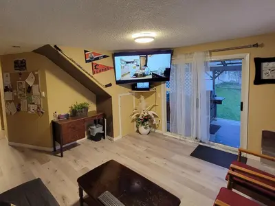 a living room with a flat screen tv on the wall at GRIZZLY MOTEL in Swan Hills