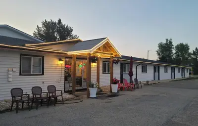 a row of houses with chairs and tables outside of them at GRIZZLY MOTEL in Swan Hills