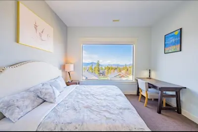 a bedroom with a bed and a desk and a window at Lakeview 2-bed 2-bath Entire Suite near Summerhill Winery in Kelowna