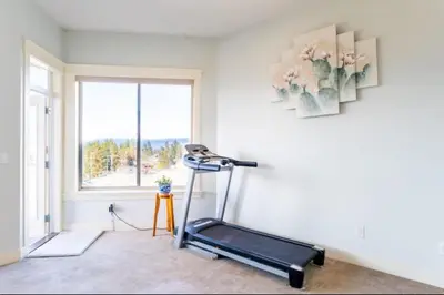 a room with a treadmill in front of a window at Lakeview 2-bed 2-bath Entire Suite near Summerhill Winery in Kelowna