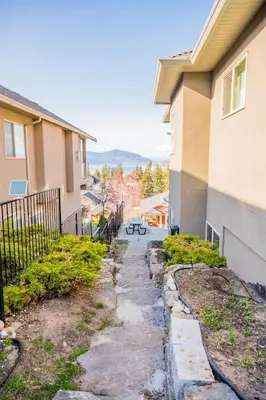 a sidewalk in front of a building with a picnic table at Lakeview 2-bed 2-bath Entire Suite near Summerhill Winery in Kelowna
