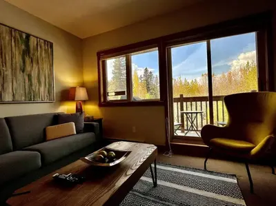 a living room with a couch and a coffee table at L202 - A Relaxed Vacation- 2BD+2BT, Heated Pool, Hot tubs, Gym, AC, Parkade in Canmore