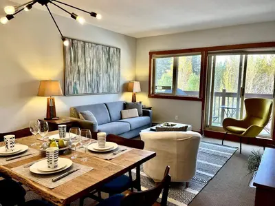a living room with a table and a couch at L202 - A Relaxed Vacation- 2BD+2BT, Heated Pool, Hot tubs, Gym, AC, Parkade in Canmore