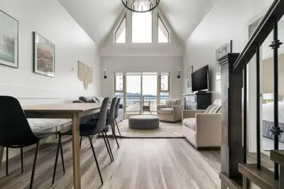 a dining room with a table and chairs and a living room at Lakeview Splendor- 7BR Penthouse Bliss Combo unit in Harrison Hot Springs