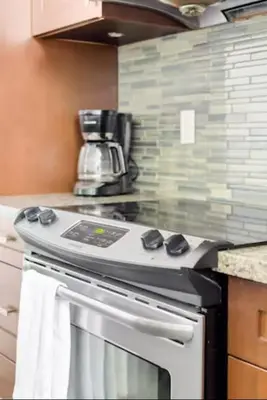 a kitchen with a stove with a coffee pot on top at Lakeview Splendor- 7BR Penthouse Bliss Combo unit in Harrison Hot Springs