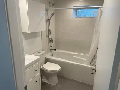 a bathroom with a toilet and a tub and a sink at Large 2 bedroom private suite ! in North Vancouver