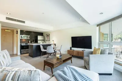 a living room with a couch and a tv at Le Chamois by Outpost Whistler in Whistler