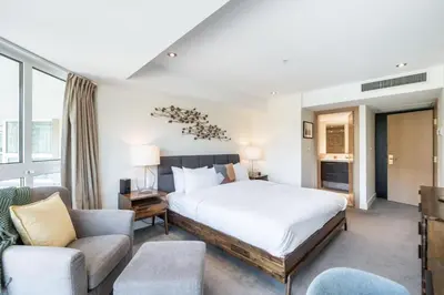 a bedroom with a large bed and a living room at Le Chamois by Outpost Whistler in Whistler