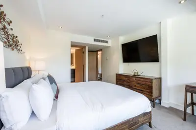 a bedroom with a bed and a flat screen tv at Le Chamois by Outpost Whistler in Whistler