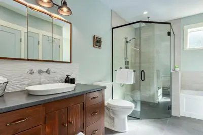 a bathroom with a toilet and a glass shower at The Nest in Lantzville