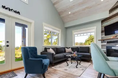 a living room with a couch and chairs and a fireplace at The Nest in Lantzville