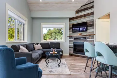 a living room with a couch and a table and chairs at The Nest in Lantzville