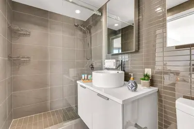 a bathroom with a white sink and a shower at Central Luxury Apartment with Best City Views! in Vancouver
