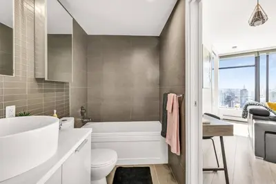 a bathroom with a tub and a toilet and a sink at Central Luxury Apartment with Best City Views! in Vancouver