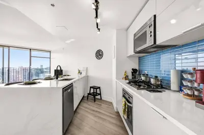 a kitchen with white counters and a large window at Central Luxury Apartment with Best City Views! in Vancouver