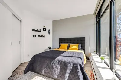 a bedroom with a large bed with yellow pillows at Central Luxury Apartment with Best City Views! in Vancouver