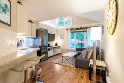 a kitchen and living room with a couch and a table at Ski nest 5m to Creekside Gondola in Whistler