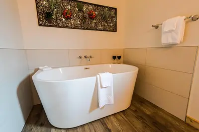 a white bath tub in a bathroom with towels at Cabins West in Ucluelet