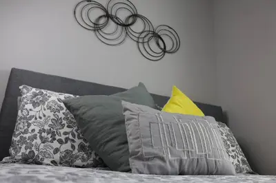 a bed with a bunch of pillows on it at Location, Location, Location-Immaculate 1 Bedroom Suite in Victoria