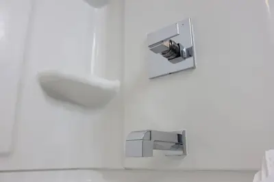 a bathroom with a faucet on a white wall at Location, Location, Location-Immaculate 1 Bedroom Suite in Victoria