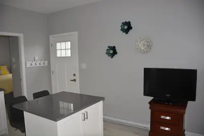 a living room with a table and a television at Location, Location, Location-Immaculate 1 Bedroom Suite in Victoria