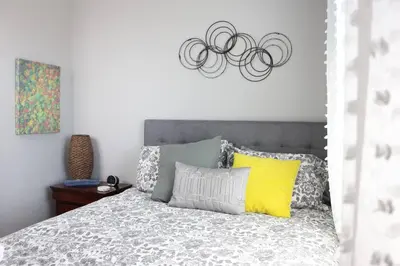 a bedroom with a bed with a yellow pillow at Location, Location, Location-Immaculate 1 Bedroom Suite in Victoria
