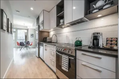 a kitchen with white cabinets and a stove top oven at Cityzen Sanctuary in Victoria