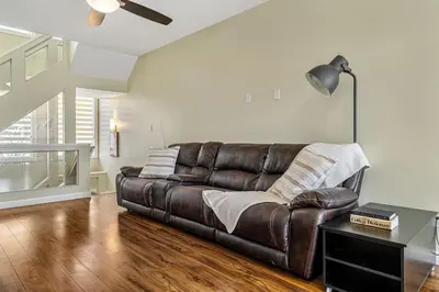 a brown leather couch in a living room at 5 Bedroom House in McConachie, Near Anthony Henday, Sleeps 12, Backyard, Netflix, Free Parking in Edmonton