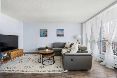 a living room with a couch and a table at Prime Location Near Jasper Ave with Downtown Views, Netflix, Gym, Sauna, Sleeps 4 in Edmonton