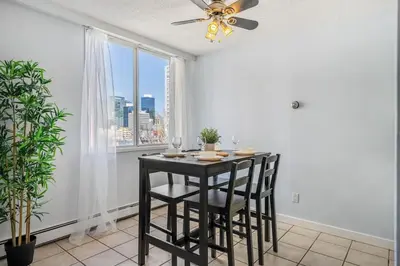 a dining room with a table and chairs and a window at Prime Location Near Jasper Ave with Downtown Views, Netflix, Gym, Sauna, Sleeps 4 in Edmonton