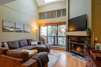 a living room with a couch and a fireplace at 3BR in Wintergreen, Family Sized, Wood Burning Fireplace, Secure Parking, Ski Hill Bus Access in Whistler