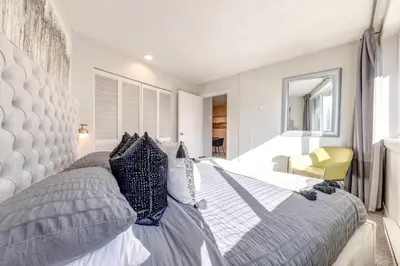 a bedroom with a large bed and a yellow chair at 1Bd Unit In the heart of Whistler Village in Whistler